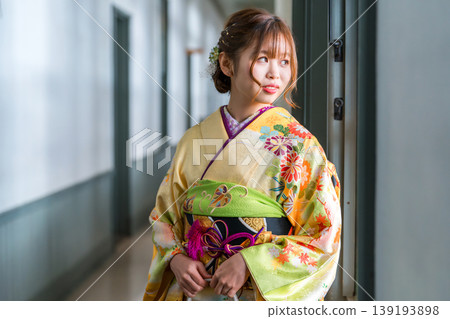 一位身穿振袖和服的20歲女子站在一棟復古的西式古董宅邸/工作室的窗邊。 139193898