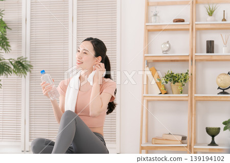 A woman in sportswear hydrating A woman in sportswear hydrating 139194102