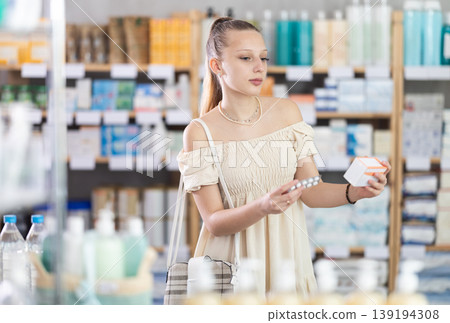 Girl in summer clothes looking for medicine in pharmacy 139194308