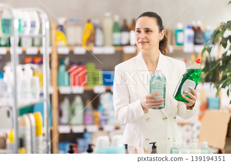 Adult woman chooses dishwashing detergent in store Adult woman chooses dishwashing detergent in store 139194351