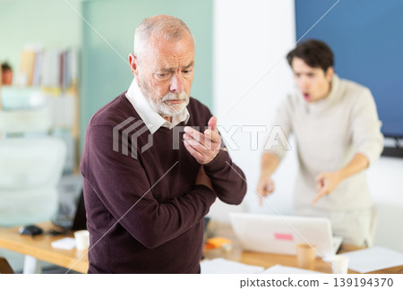 Outraged senior man turned his back on angry and shouting man boss. Outraged senior man turned his back on angry and shouting man boss. 139194370