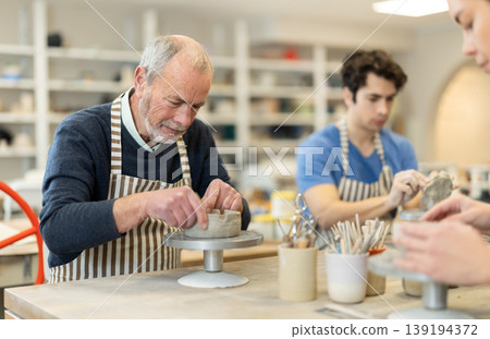 Young woman and man and elderly man crafting ceramics Young woman and man and elderly man crafting ceramics 139194372