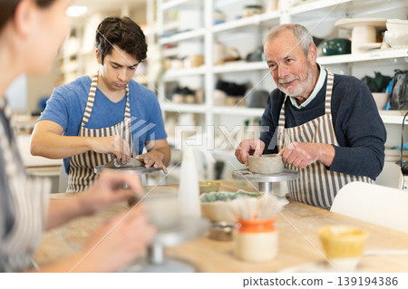 Young woman and man and elderly man crafting ceramics Young woman and man and elderly man crafting ceramics 139194386