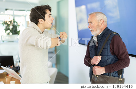 Young man scolding elderly male colleague for being late to office Young man scolding elderly male colleague for being late to office 139194416