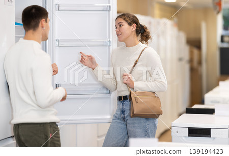 Couple choosing a refrigerator in an equipment store Couple choosing a refrigerator in an equipment store 139194423