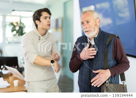 Young man scolding elderly male colleague for being late to office 139194444