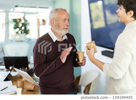 Male colleagues drink coffee and have nice conversation during break Male colleagues drink coffee and have nice conversation during break 139194485