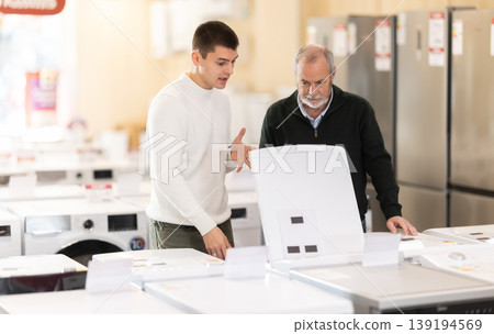 Men of different ages choose a dishwasher and a washing machine Men of different ages choose a dishwasher and a washing machine 139194569