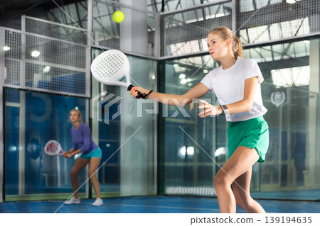 Teenage girl playing padel in court Teenage girl playing padel in court 139194635