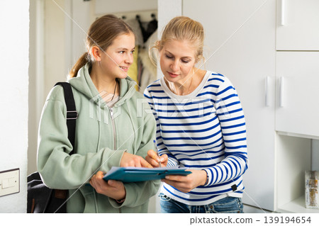 Teenage interviewer making voter survey of woman Teenage interviewer making voter survey of woman 139194654