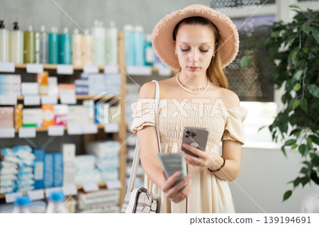 Young pregnant woman scans a package of cream Young pregnant woman scans a package of cream 139194691
