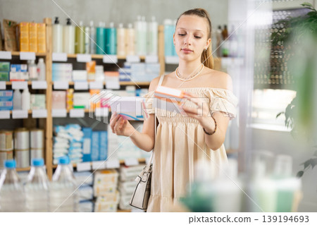 Girl in summer clothes looking for medicine in pharmacy 139194693
