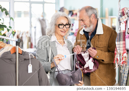 Mature couple spend time in shop and choose bra lingerie set 139194695
