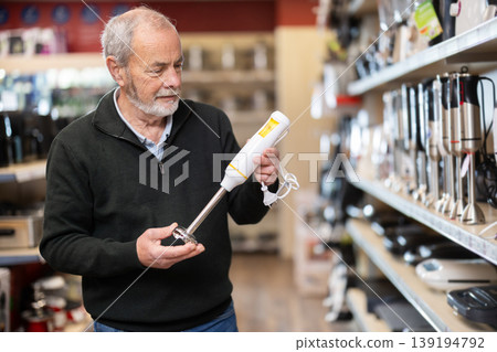 Elderly man choosing a blender in a store Elderly man choosing a blender in a store 139194792
