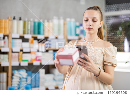 Pregnant woman in pharmacy scans QR code tablet medication product 139194808