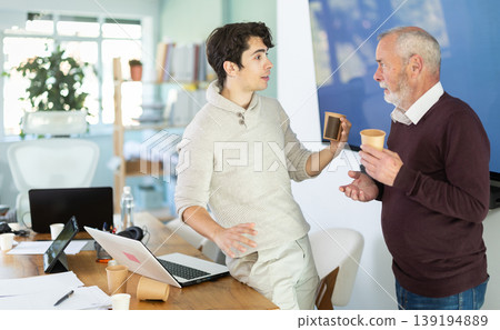 Male colleagues drink coffee and have nice conversation during break Male colleagues drink coffee and have nice conversation during break 139194889