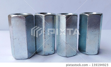 Close-up image of hexagon coupling nut, metal hardware fastener, threaded steel connector for industrial use. Close-up image of hexagon coupling nut, metal hardware fastener, threaded steel connector for industrial use. 139194923
