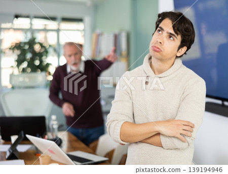 Adult man experiences abuse at work, is criticized by his mature male superiors. Adult man experiences abuse at work, is criticized by his mature male superiors. 139194946
