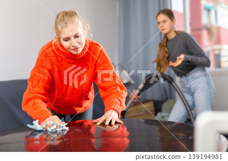 Woman wiping the table at home Woman wiping the table at home 139194981