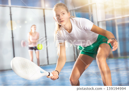 Active teen girl playing padel on tennis court Active teen girl playing padel on tennis court 139194994