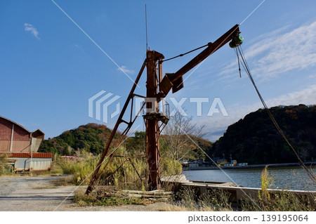 A rusty cargo lifting crane on the lakeshore A rusty cargo lifting crane on the lakeshore 139195064