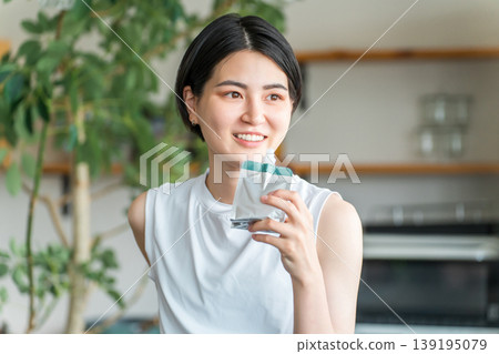 A young Asian woman in sportswear drinking jelly and replenishing her energy with nutritional supplement jelly 139195079