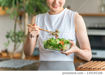 A young woman in sportswear eating a diet menu A young woman in sportswear eating a diet menu 139195106