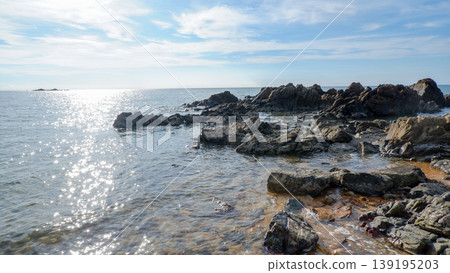 Sparkling Sea Water and Rocks Under Bright Sunlight 139195203