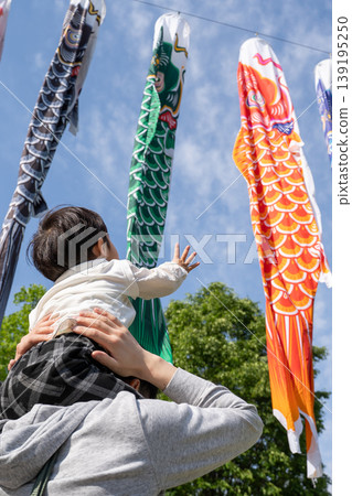 一位家長和孩子抬頭看著鯉魚擬餌。 139195250