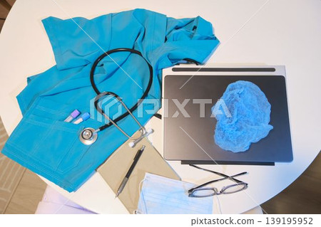 Medical scrubs, stethoscope, and healthcare equipment on table Medical scrubs, stethoscope, and healthcare equipment on table 139195952