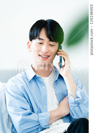 A man talking on the phone in the living room A man talking on the phone in the living room 139196003