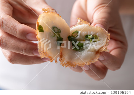 Eating Thai coconut pancakes (Khanom Krok) with spring onion topping by hand Eating Thai coconut pancakes (Khanom Krok) with spring onion topping by hand 139196194