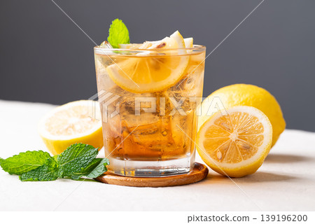 Refreshing iced lemon tea in a glass with sliced lemon and mint leaves Refreshing iced lemon tea in a glass with sliced lemon and mint leaves 139196200