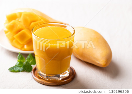 Fresh mango smoothie in a glass with ripe mango slices Fresh mango smoothie in a glass with ripe mango slices 139196206