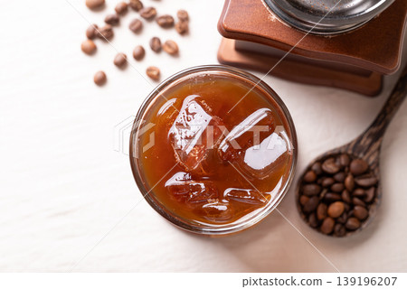 Iced americano coffee in a glass with roasted coffee beans. Popular refreshing summer drink Iced americano coffee in a glass with roasted coffee beans. Popular refreshing summer drink 139196207