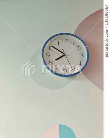 Blue-rimmed wall clock displaying the time Blue-rimmed wall clock displaying the time 139196567