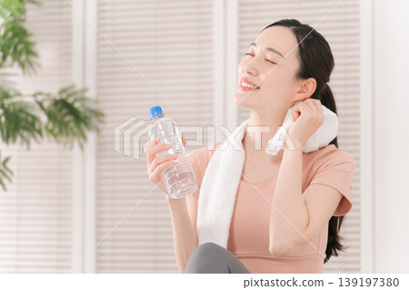 一位女性正在鍛鍊並補充水分。 一位女性正在鍛鍊並補充水分。 139197380