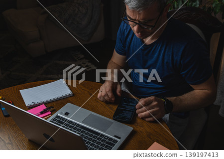 Freelancer working on laptop at desk home office lifestyle Freelancer working on laptop at desk home office lifestyle 139197413