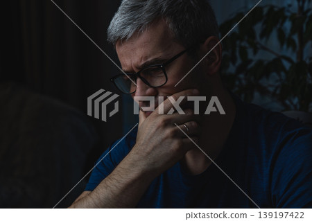 Thoughtful man resting chin while working on laptop at home 139197422