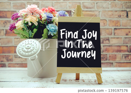 Find Joy In The Journey text on black wooden easel and vase with flowers bouquet on brick wall background Find Joy In The Journey text on black wooden easel and vase with flowers bouquet on brick wall background 139197576