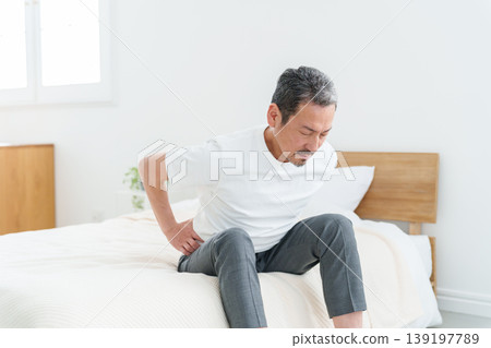 Middle-aged and elderly men suffering from lower back pain. 139197789