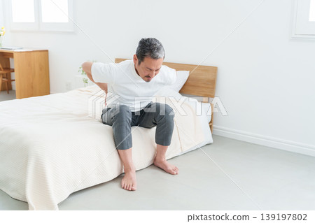 Middle-aged and elderly men suffering from lower back pain. 139197802