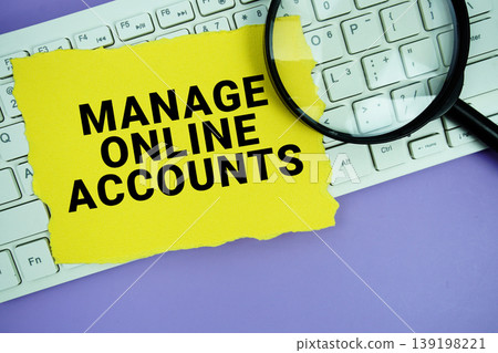 Yellow paper with text "Manage Online Accounts" and magnifying glass placed on a white keyboard Yellow paper with text "Manage Online Accounts" and magnifying glass placed on a white keyboard 139198221