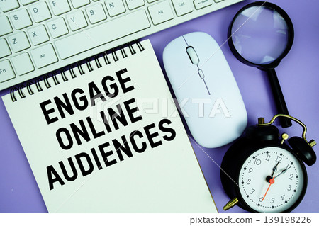 Notepad with the text "Engage Online Audiences" and white keyboard, wireless mouse, magnifying glass and alarm clock Notepad with the text "Engage Online Audiences" and white keyboard, wireless mouse, magnifying glass and alarm clock 139198226