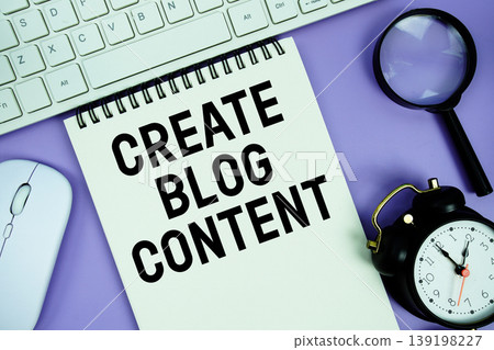 Notepad with the text "Create Blog Content" and white keyboard, wireless mouse, magnifying glass and alarm clock Notepad with the text "Create Blog Content" and white keyboard, wireless mouse, magnifying glass and alarm clock 139198227