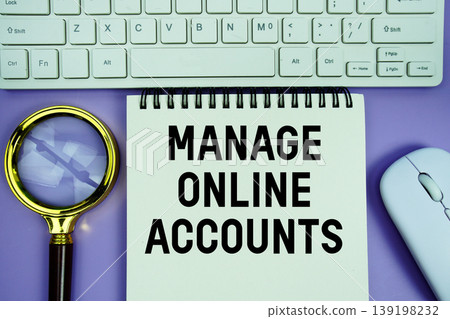 Notepad with the text "Manage Online Accounts" and white keyboard, wireless mouse and magnifying glass on purple background 139198232