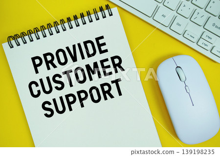 Notepad with the text "Provide Customer Support" and white keyboard and wireless mouse on yellow background 139198235