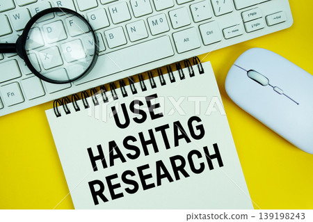 Notepad with the text "Use Hashtag Research" and white keyboard, wireless mouse and magnifying glass on yellow background Notepad with the text "Use Hashtag Research" and white keyboard, wireless mouse and magnifying glass on yellow background 139198243