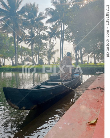 A scene of everyday life in Kerala: small boats preparing for the morning along a backwater canal lined with palm trees. A scene of everyday life in Kerala: small boats preparing for the morning along a backwater canal lined with palm trees. 139199212