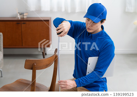 A young delivery person provides a quote for pickup; lifestyle image 139199523
